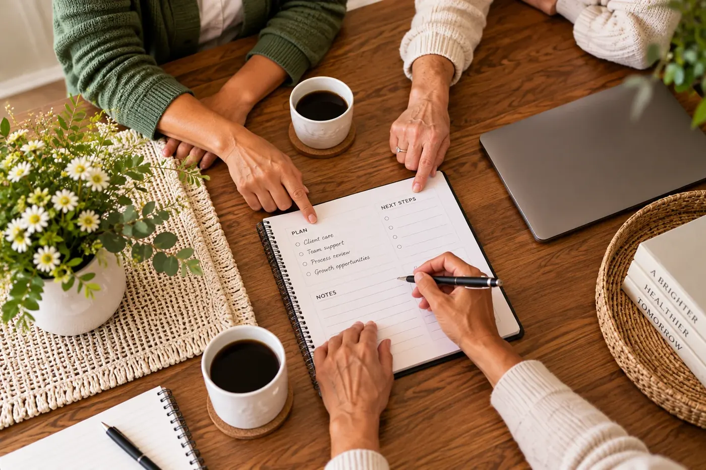 Two people at a kitchen table with a notebook between them